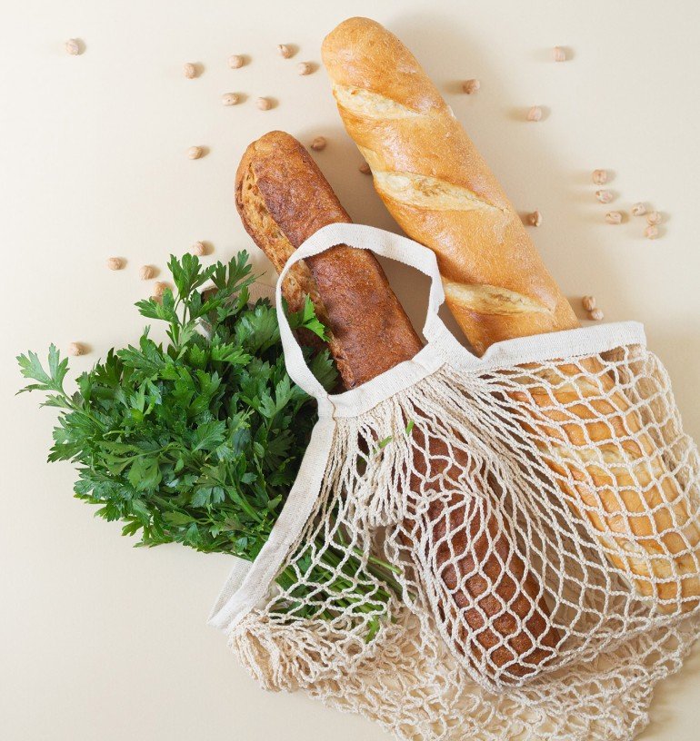 Fresh bread and produce in a reusable market bag